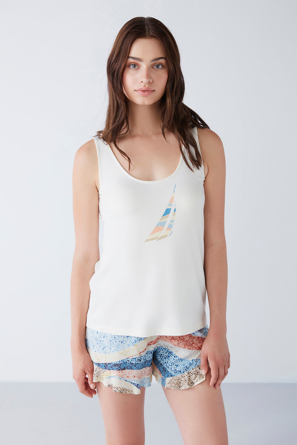 Front view of the Popjammies pyjama set with a colorful sailboat print top and mosaic pattern shorts, worn by a model.