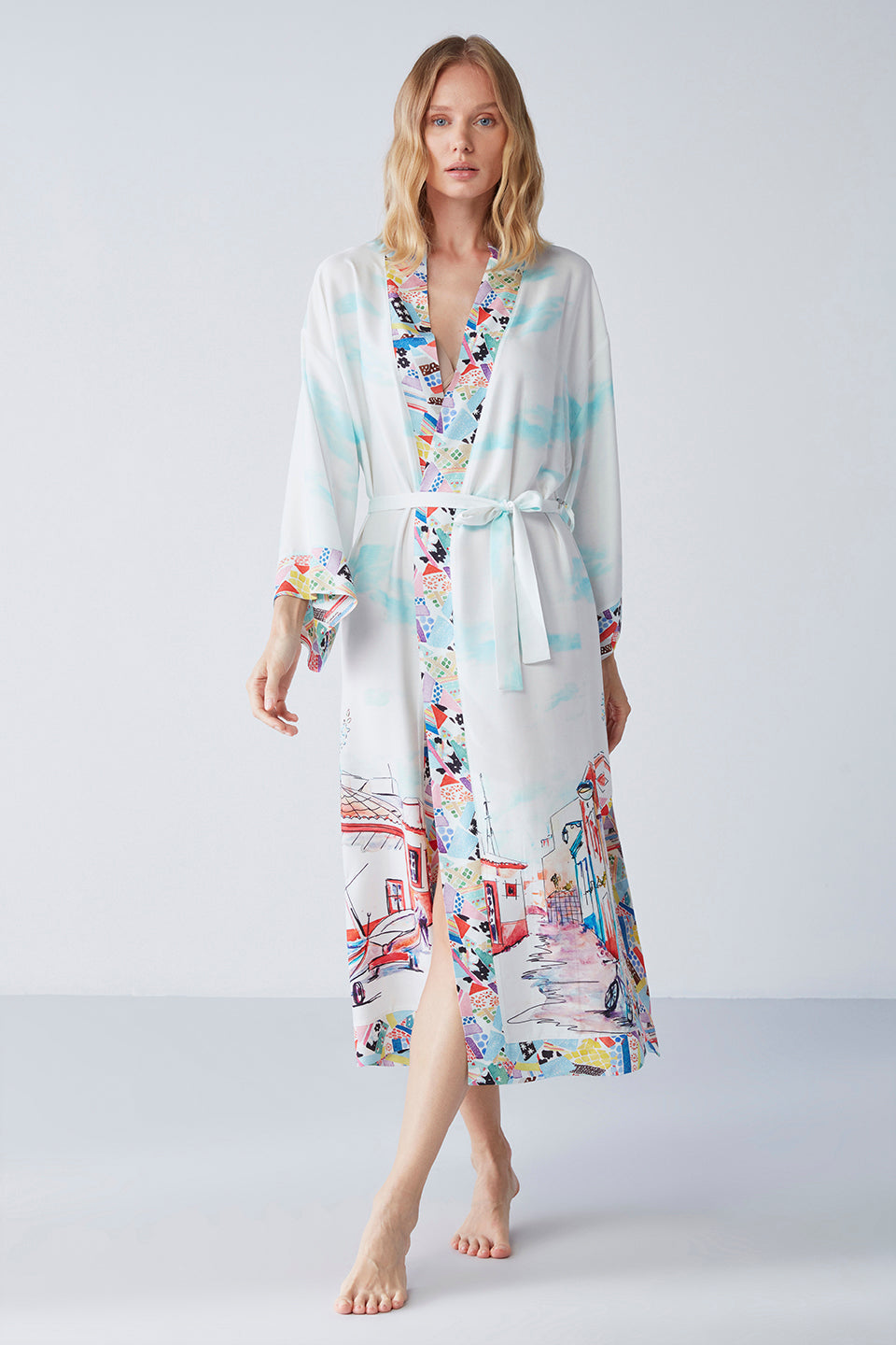 Full-length view of a woman wearing a Popjammies satin printed kimono robe with wide kimono sleeves and a vibrant pattern.