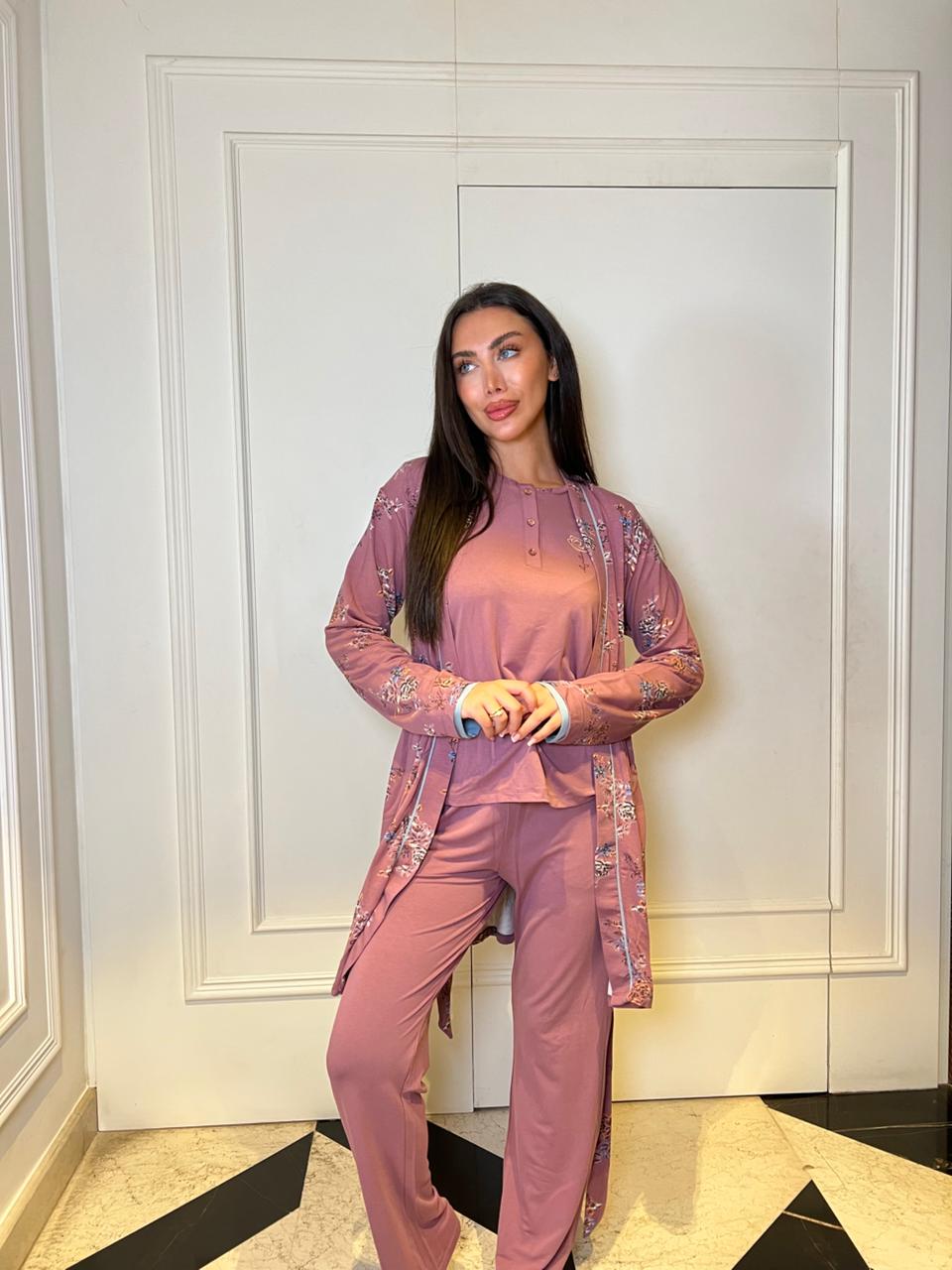 Woman in a pink outfit standing in a room with white walls and black floor.