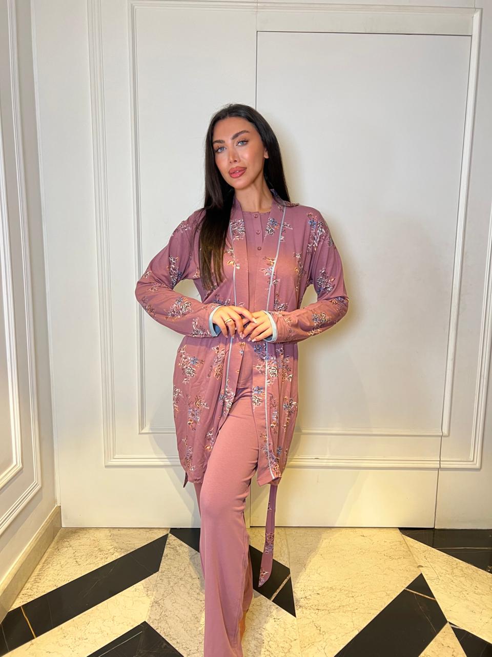 Woman in a pink outfit standing in a room with white walls and black and white checkered floor.