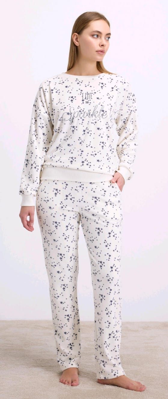 Woman wearing a white floral pajama set on a plain background