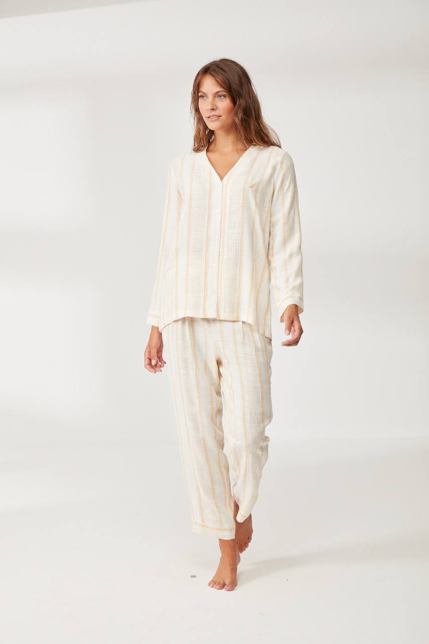 Woman wearing a long-sleeve striped cotton pyjama set from Popjammies, featuring a V-neckline and matching full-length pants, posing in a relaxed manner.