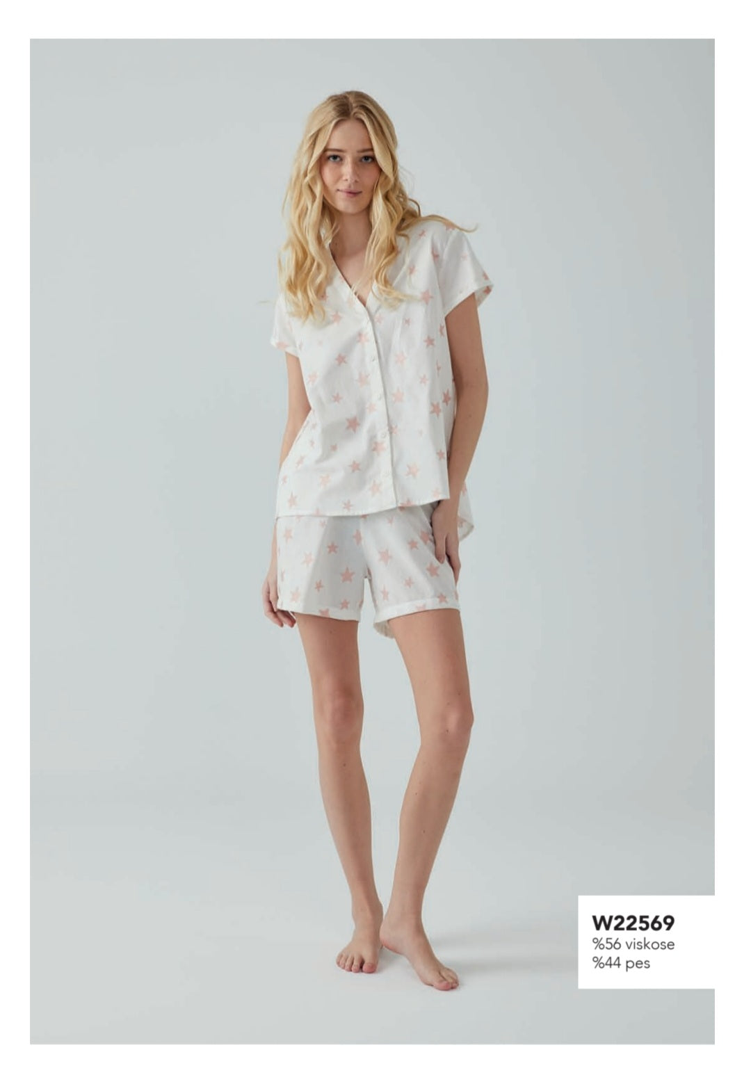 Model wearing the Starry Night Pajama Set from Popjammies, featuring a white short-sleeve button-up top and matching shorts with a pink star print.