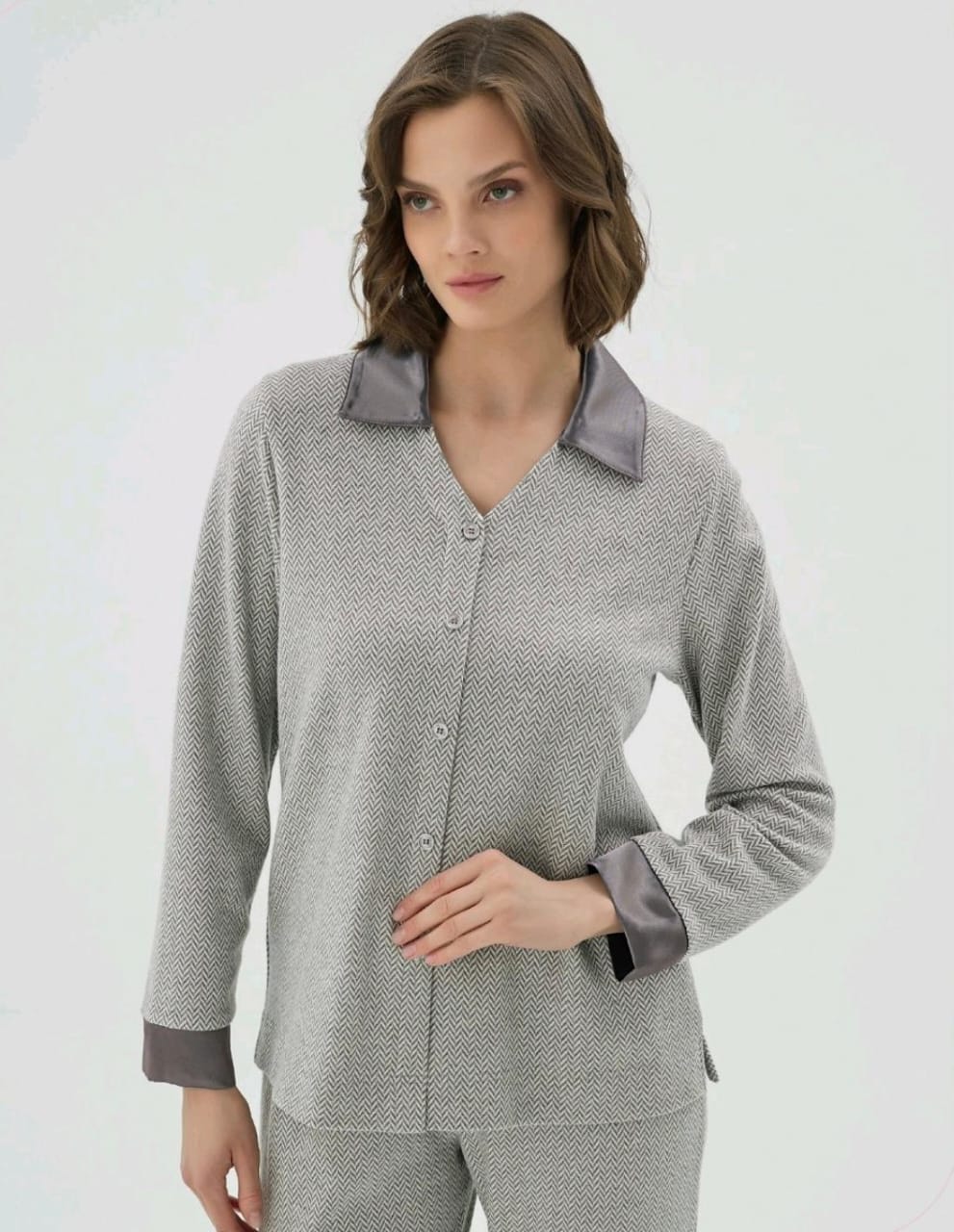 Woman wearing a gray patterned pajama set on a white background
