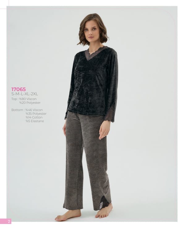 Woman wearing a black velvet top and striped pants on a gray background