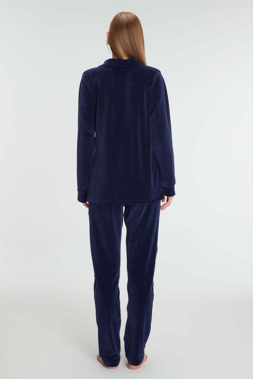 Navy blue velour pajama set worn by a person on a white background