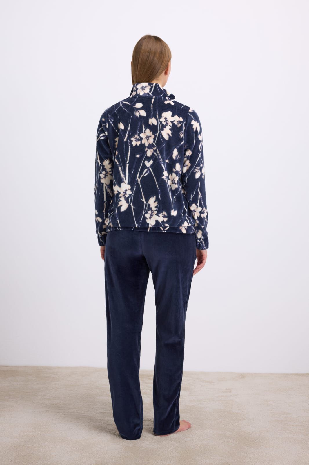 Person wearing a navy floral pajama set on a white background