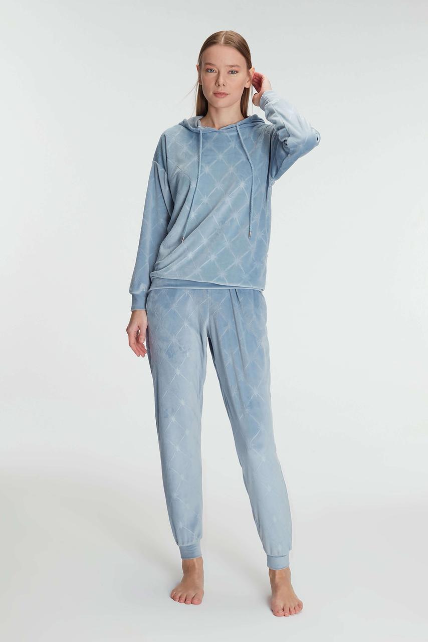 Woman wearing a light blue hoodie and pants set on a white background