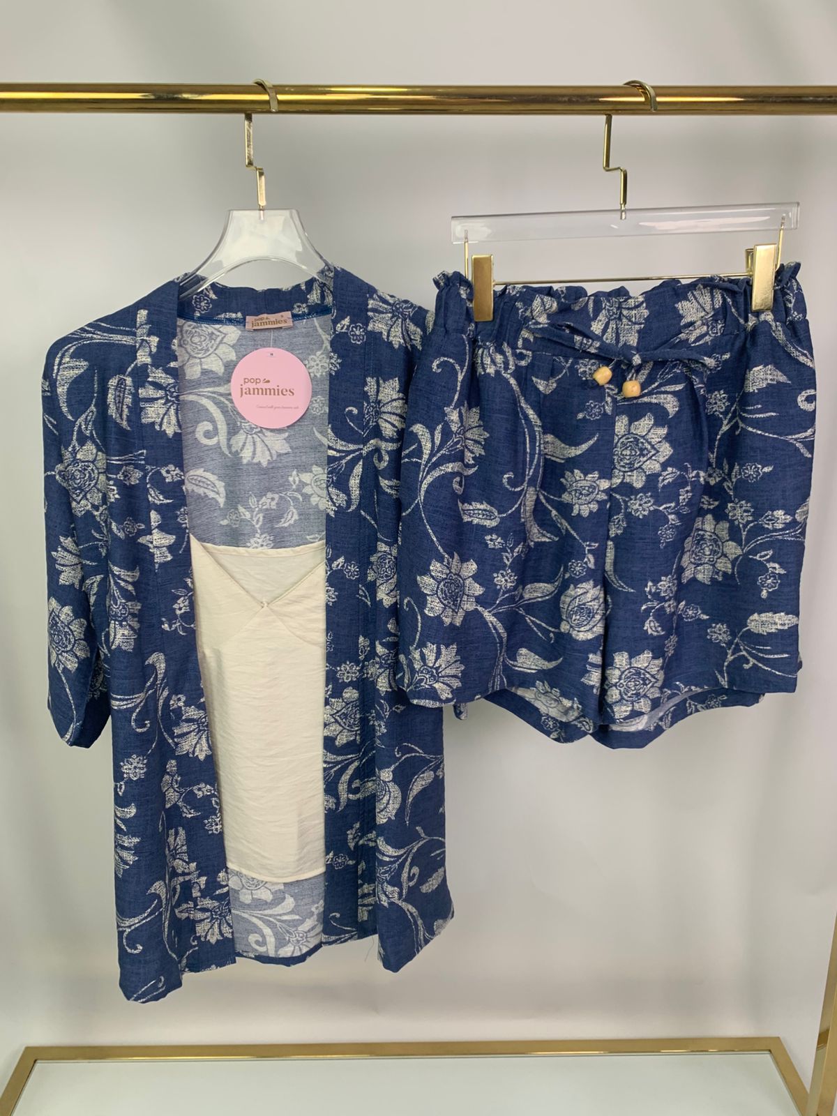 3-piece women’s short pyjama set - pajama set - summer pajama - women pajama set - Blue floral outfit with a white shirt on a rack against a white background