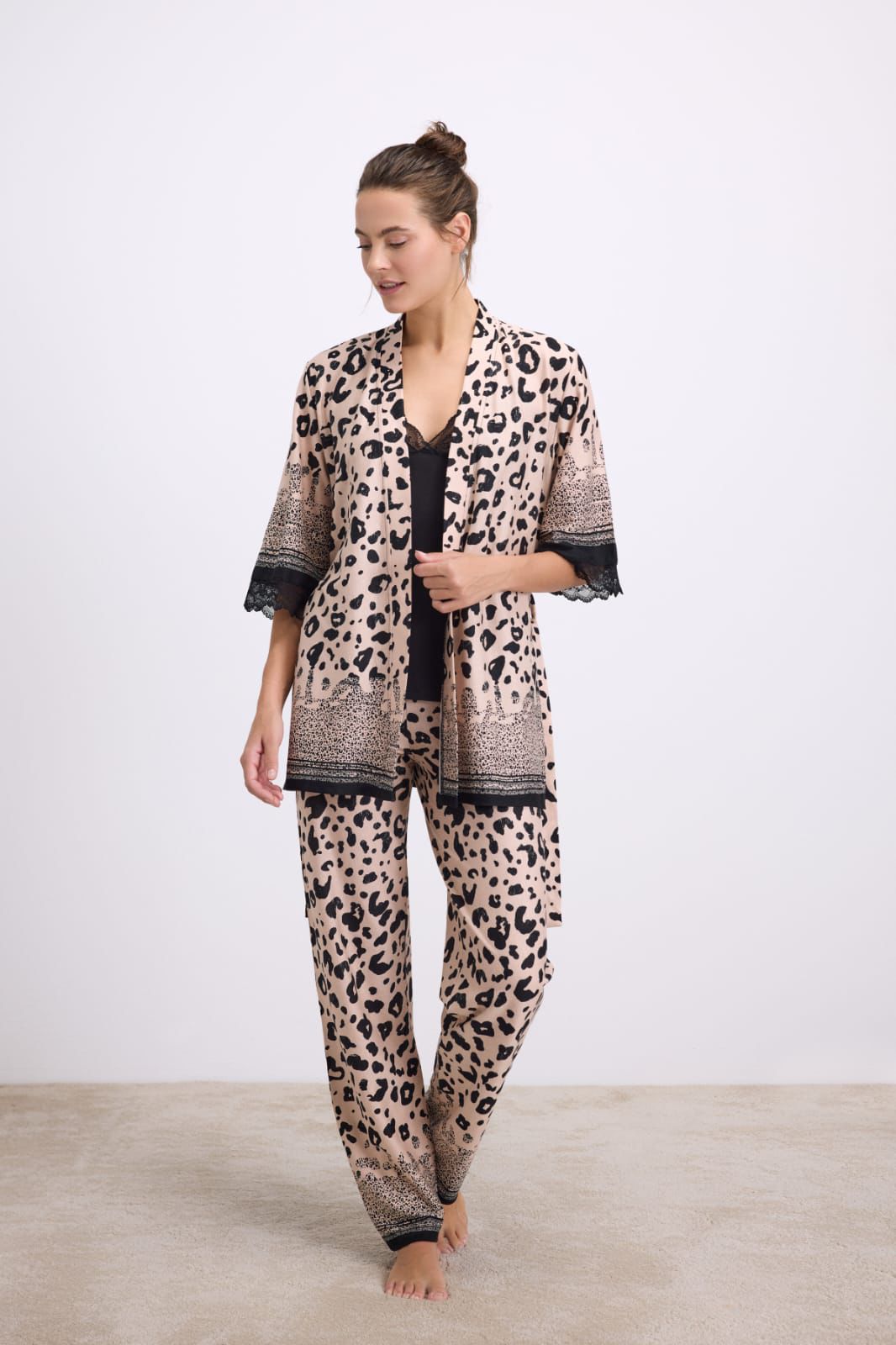 Woman wearing a leopard print kimono-style outfit on a white background