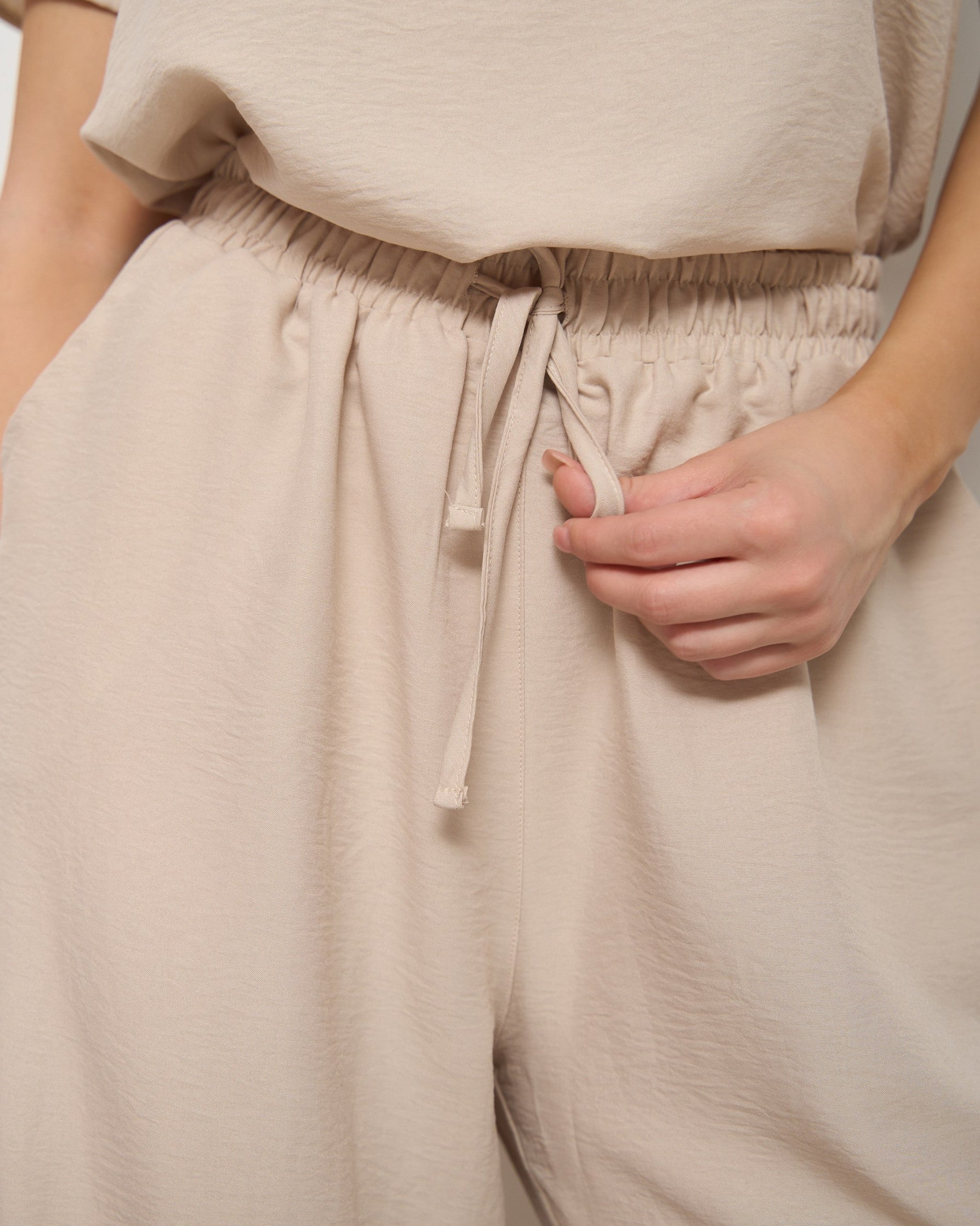 Close-up of the drawstring waist of beige pyjama pants, highlighting the soft fabric and comfortable fit by Popjammies.