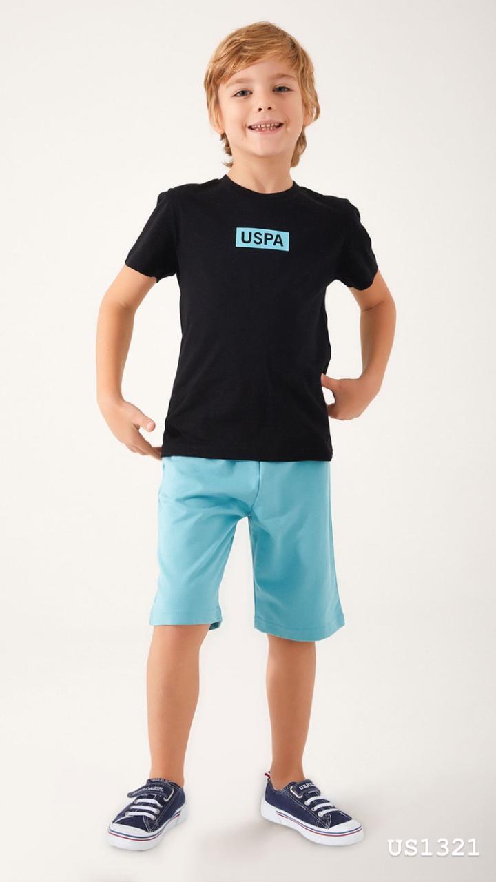 Child wearing Popjammies USPA Nightwear Set with black top and light blue shorts standing with hands on hips