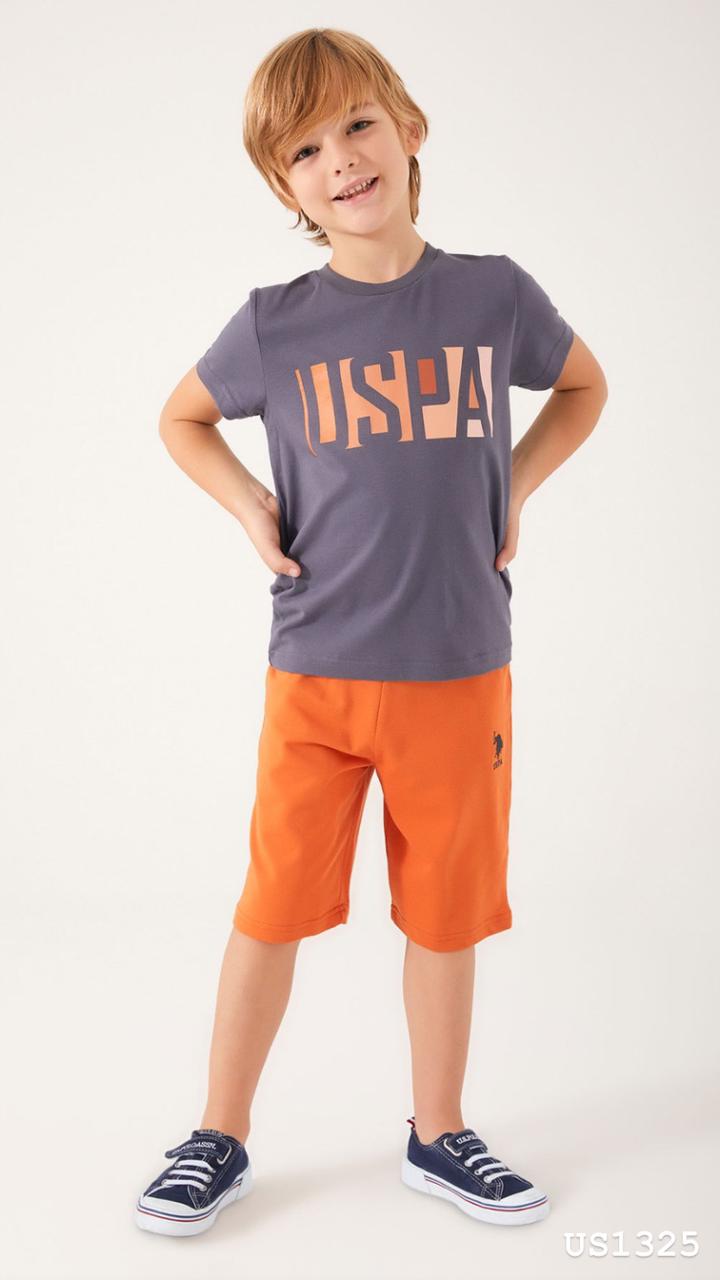 Child wearing Popjammies USPA Graphic Pyjama Set with grey top and orange shorts standing with hands on hips