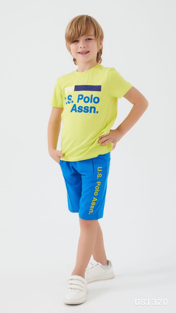 Child wearing Popjammies USPA Nightwear Set with neon yellow top and bright blue shorts standing with hand on hip