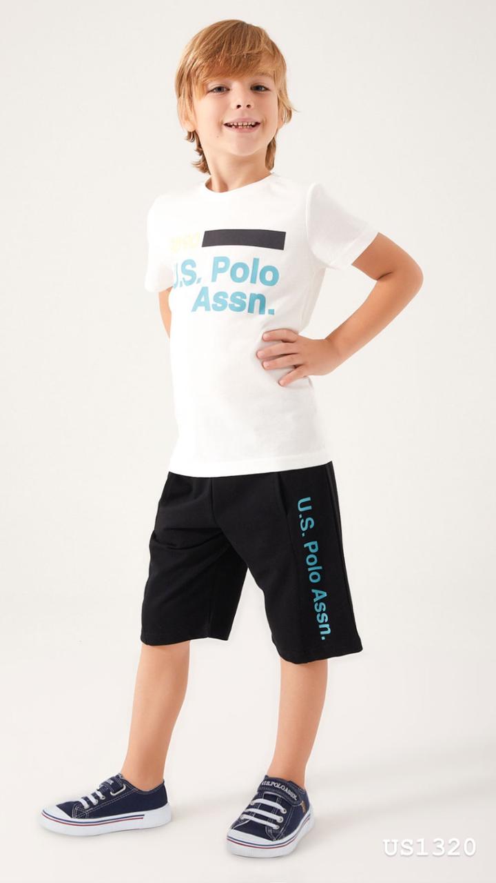 Child wearing Popjammies USPA Nightwear Set with white top and black shorts standing with hand on hip