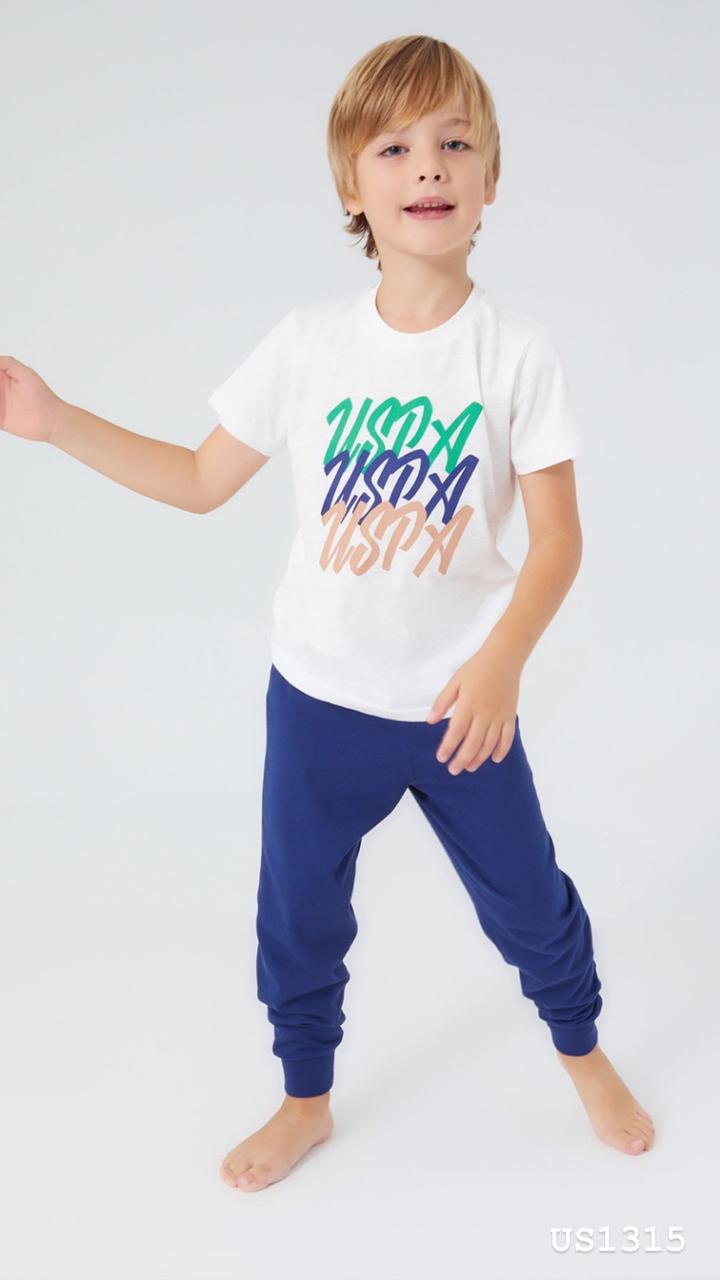 Boy wearing Popjammies white t-shirt with colorful "USPA" graphics and navy jogger pants, posing with arms extended.