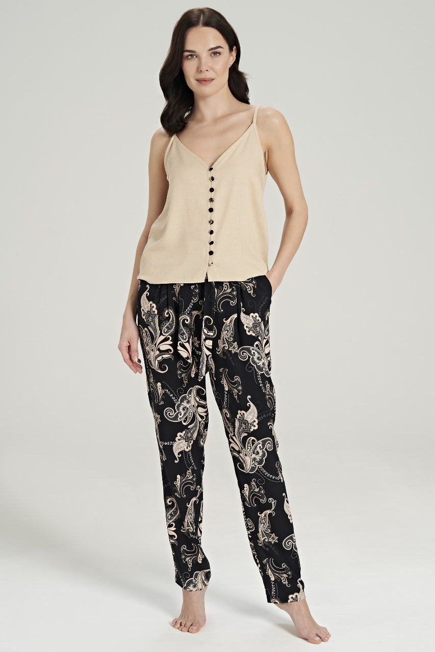 Model wearing a beige buttoned top with black paisley-patterned pants from Popjammies, standing.