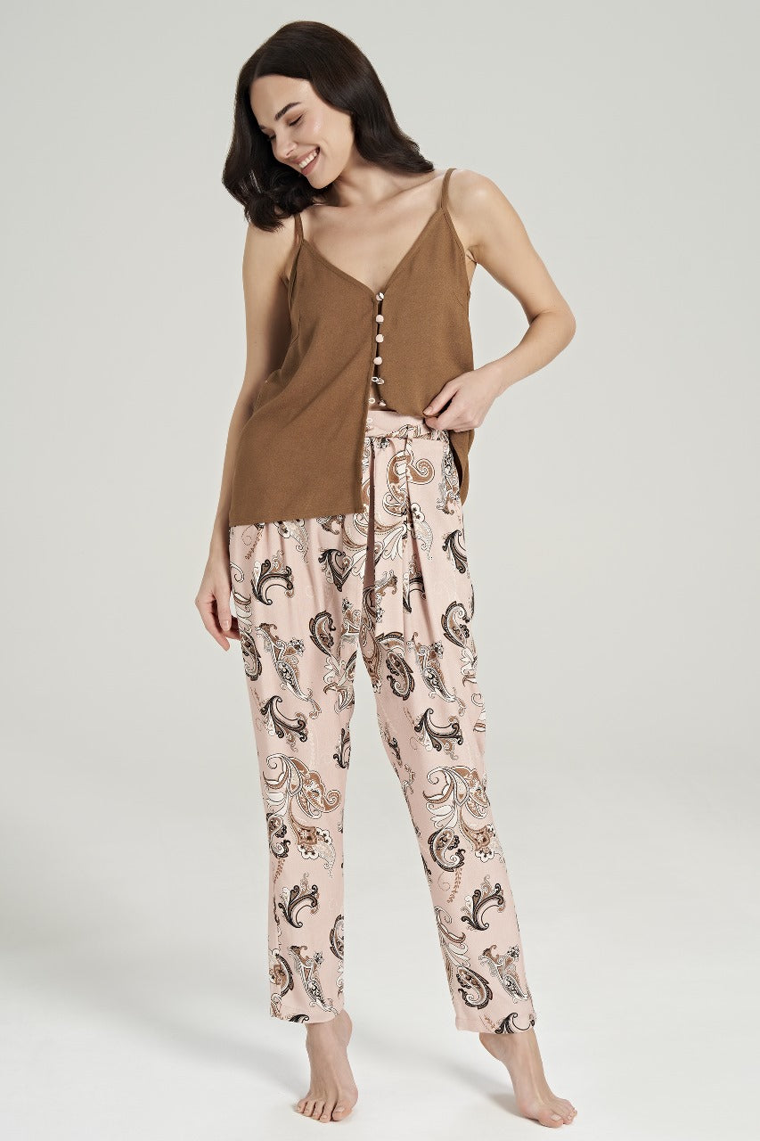 Model standing and smiling, wearing a brown buttoned top with paisley-patterned pink pants from Popjammies.