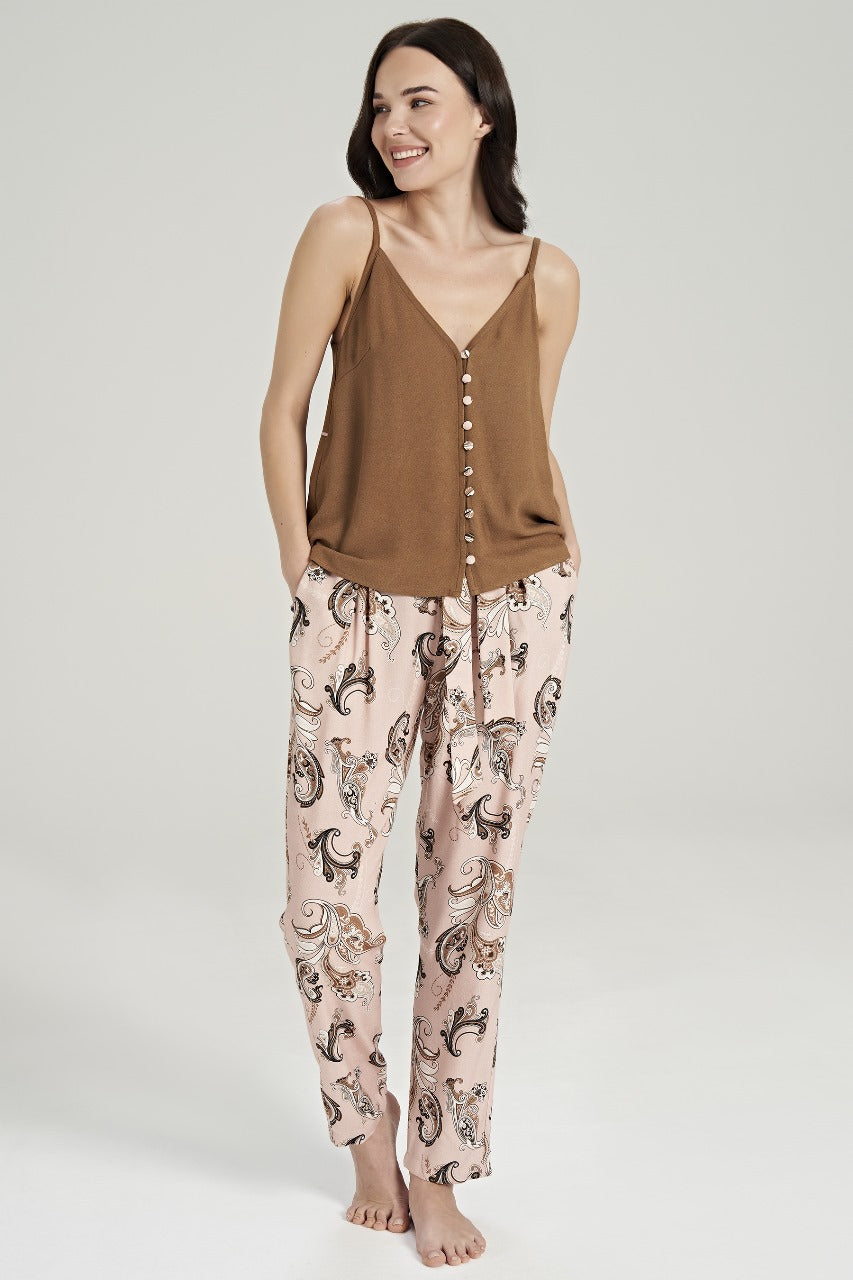 Model smiling while wearing a brown buttoned top with paisley-patterned pink pants from Popjammies.