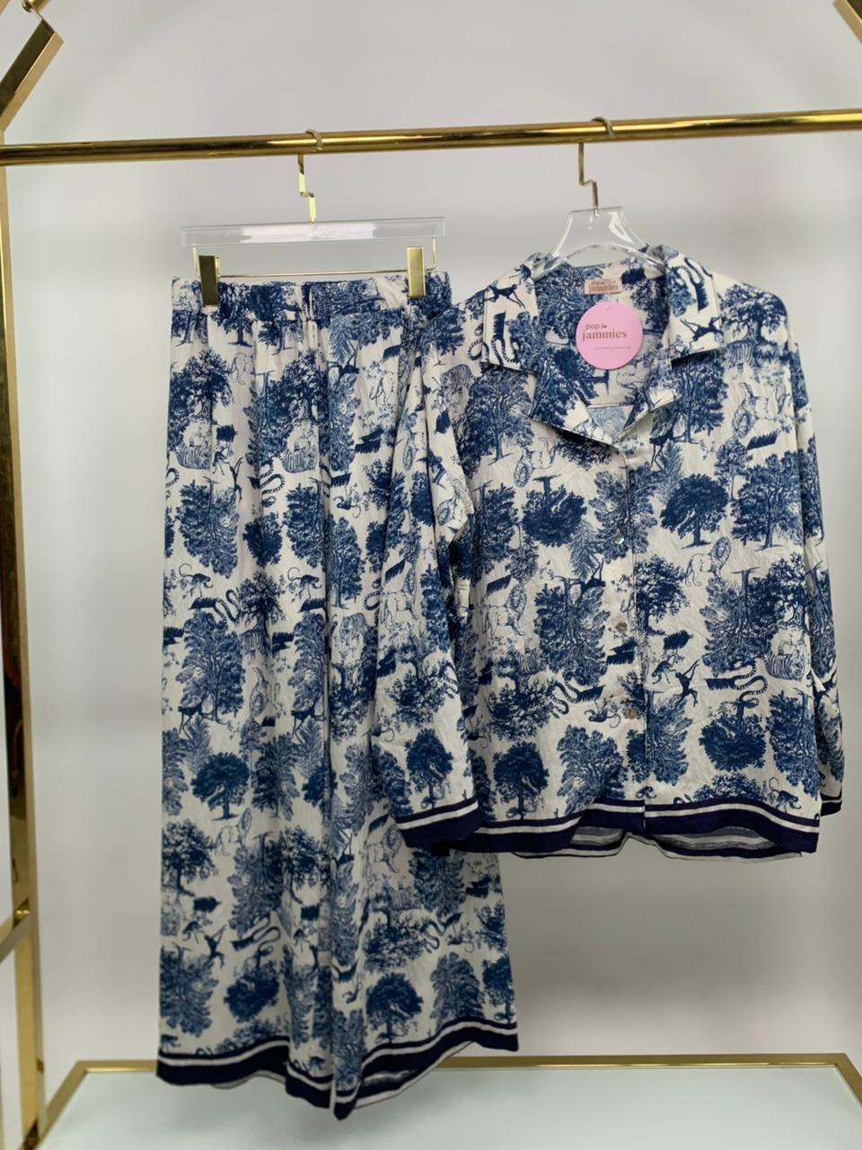 Blue and white floral pajama set on a hanger against a white background