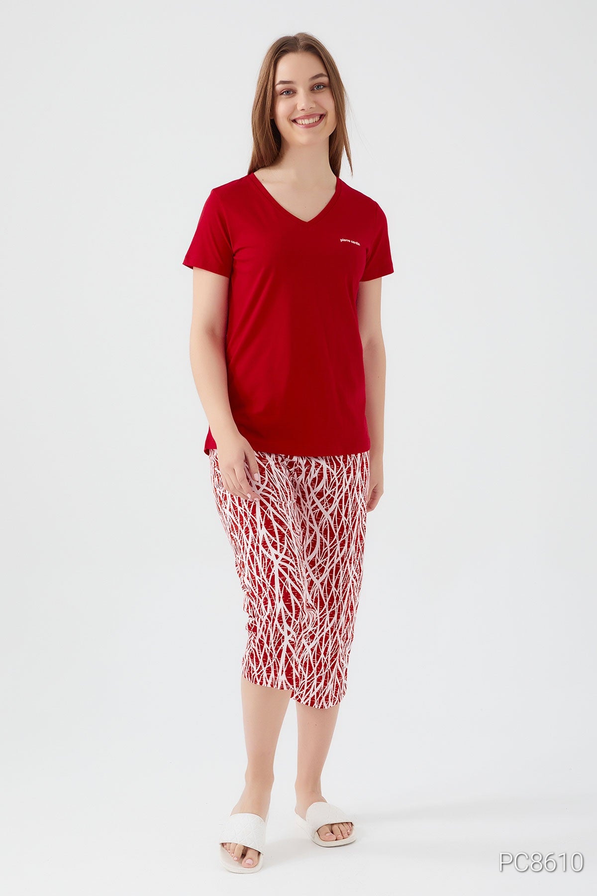 Woman wearing a Popjammies red short sleeve top with matching red pantacour featuring white patterns , smilling.
