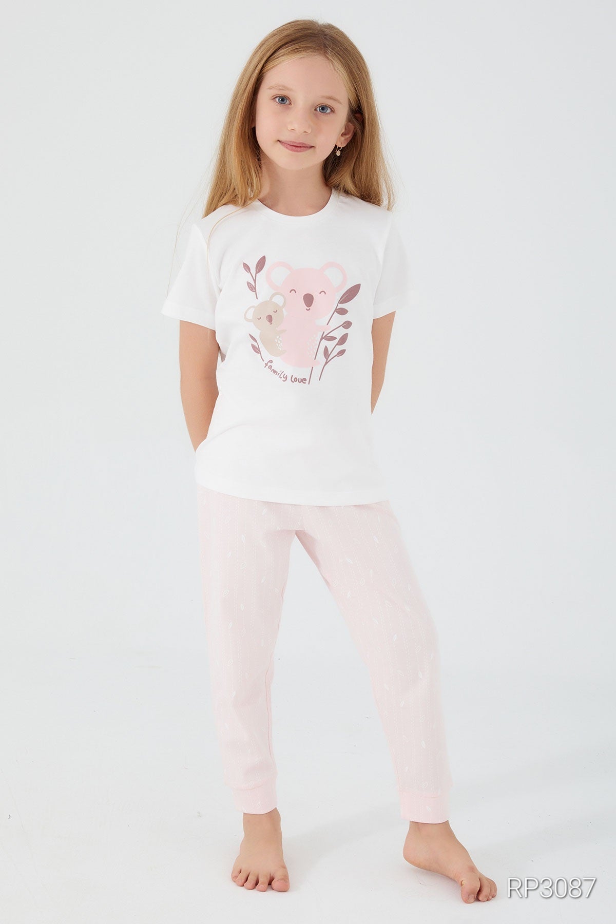 A girl posing, wearing a white short sleeve top with bears and "Family Love" text, and light pink pants, front view.
