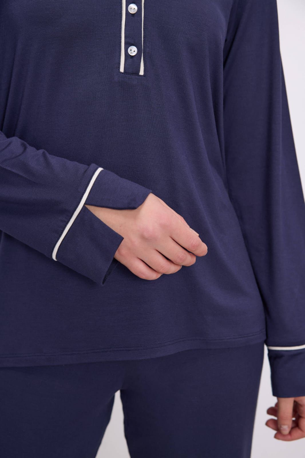 Navy blue long-sleeve shirt with white trim on a plain background