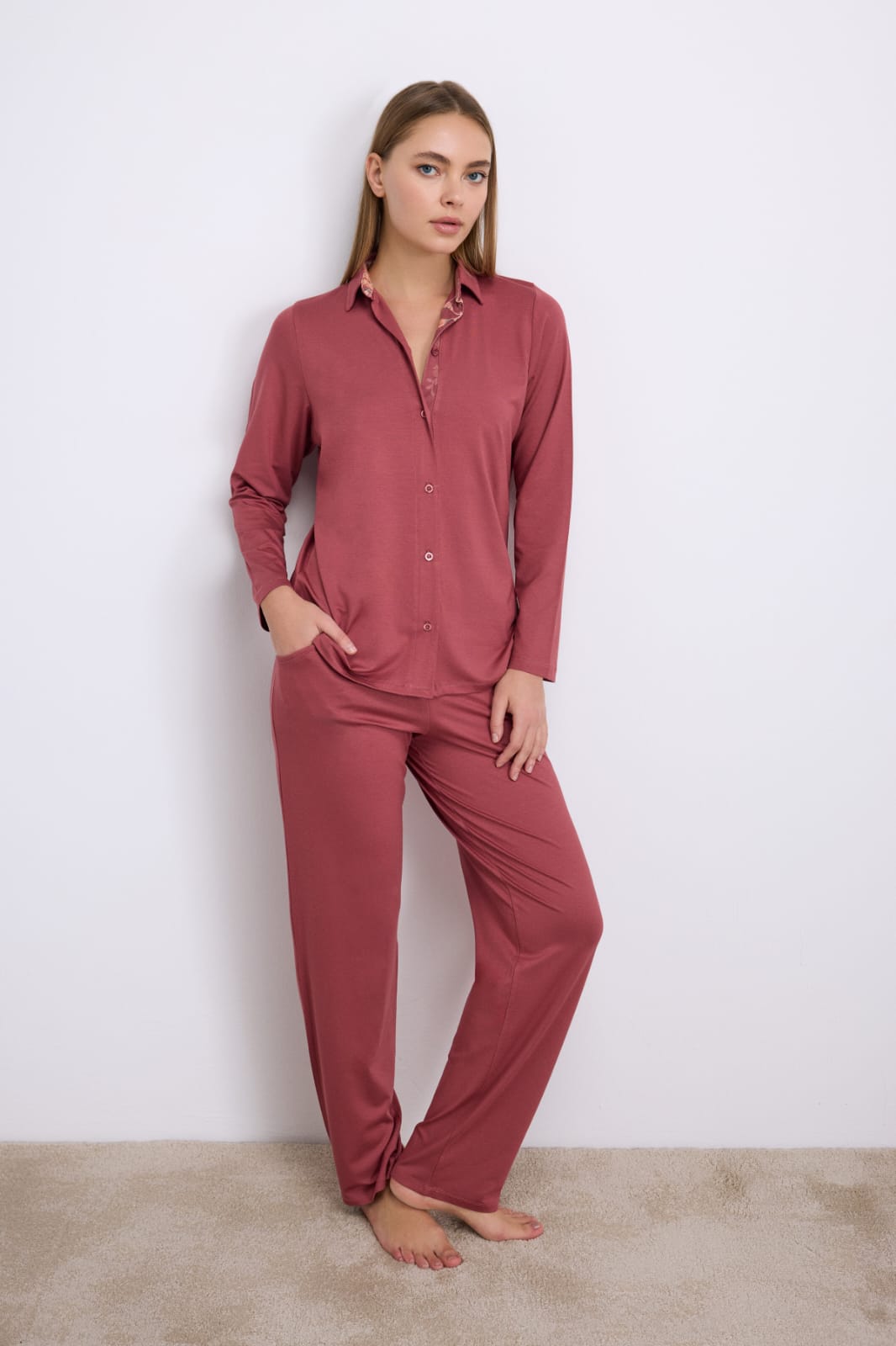 Woman wearing a red pajama set against a white background