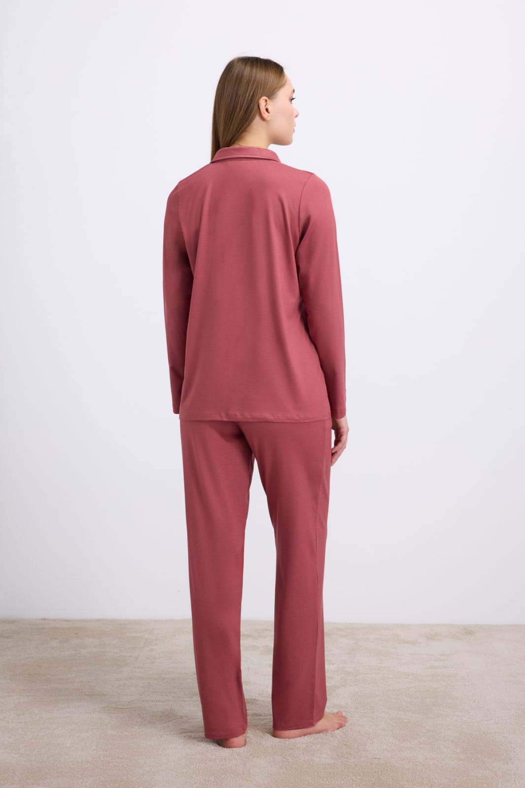 Person wearing a pink pajama set against a white background