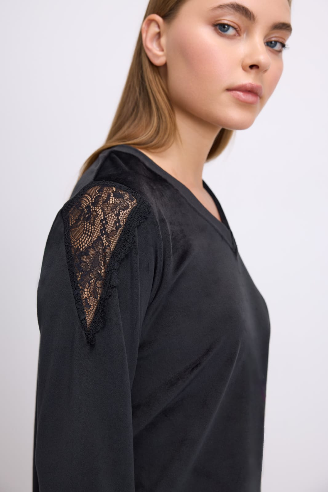 Black garment with lace detailing on a plain background