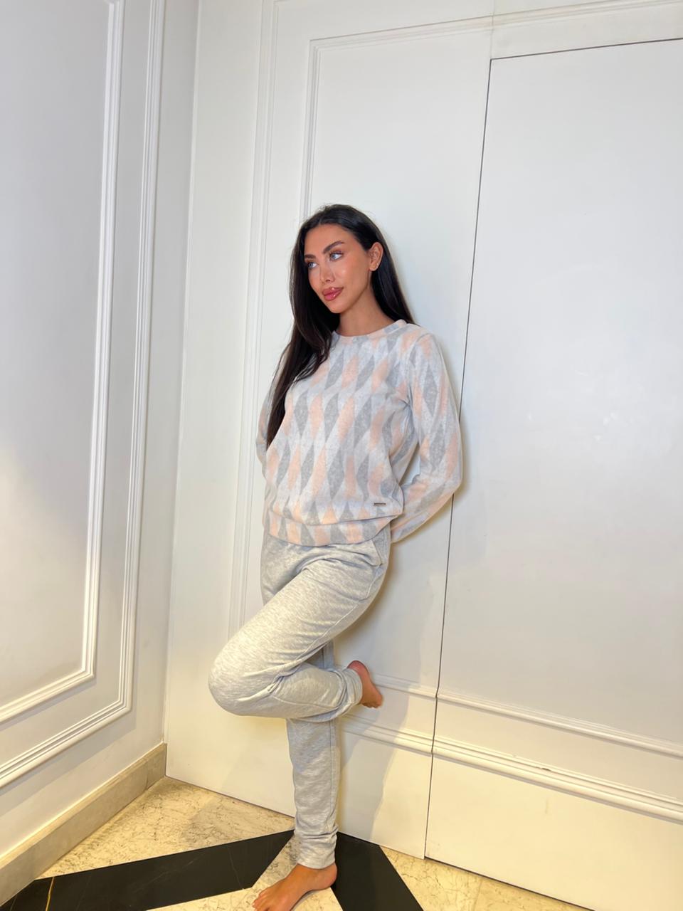Woman posing in a room with white walls and a black rug.
