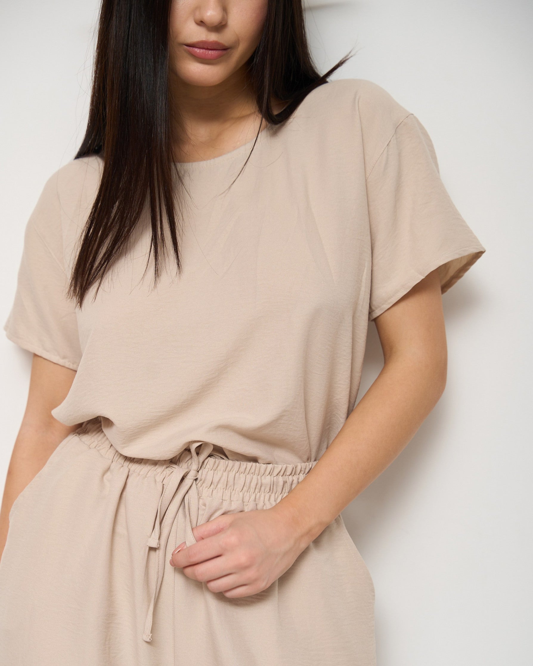 Close-up of a model wearing a beige pyjama set with a drawstring waist, highlighting the soft fabric and comfortable fit by Popjammies.