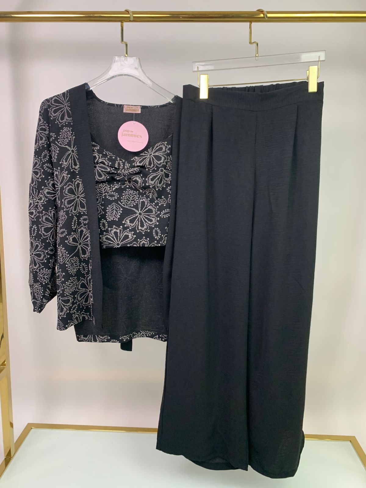 3-piece women’s pyjama set - pajama set - summer pajama - women pajama - Black floral top and wide-leg pants on hangers against a white background