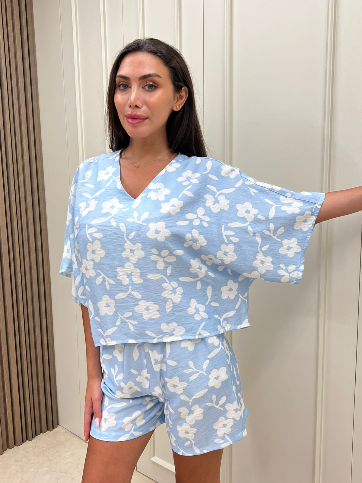 2-piece shorts pyjama set - Woman wearing a blue floral outfit against a neutral background