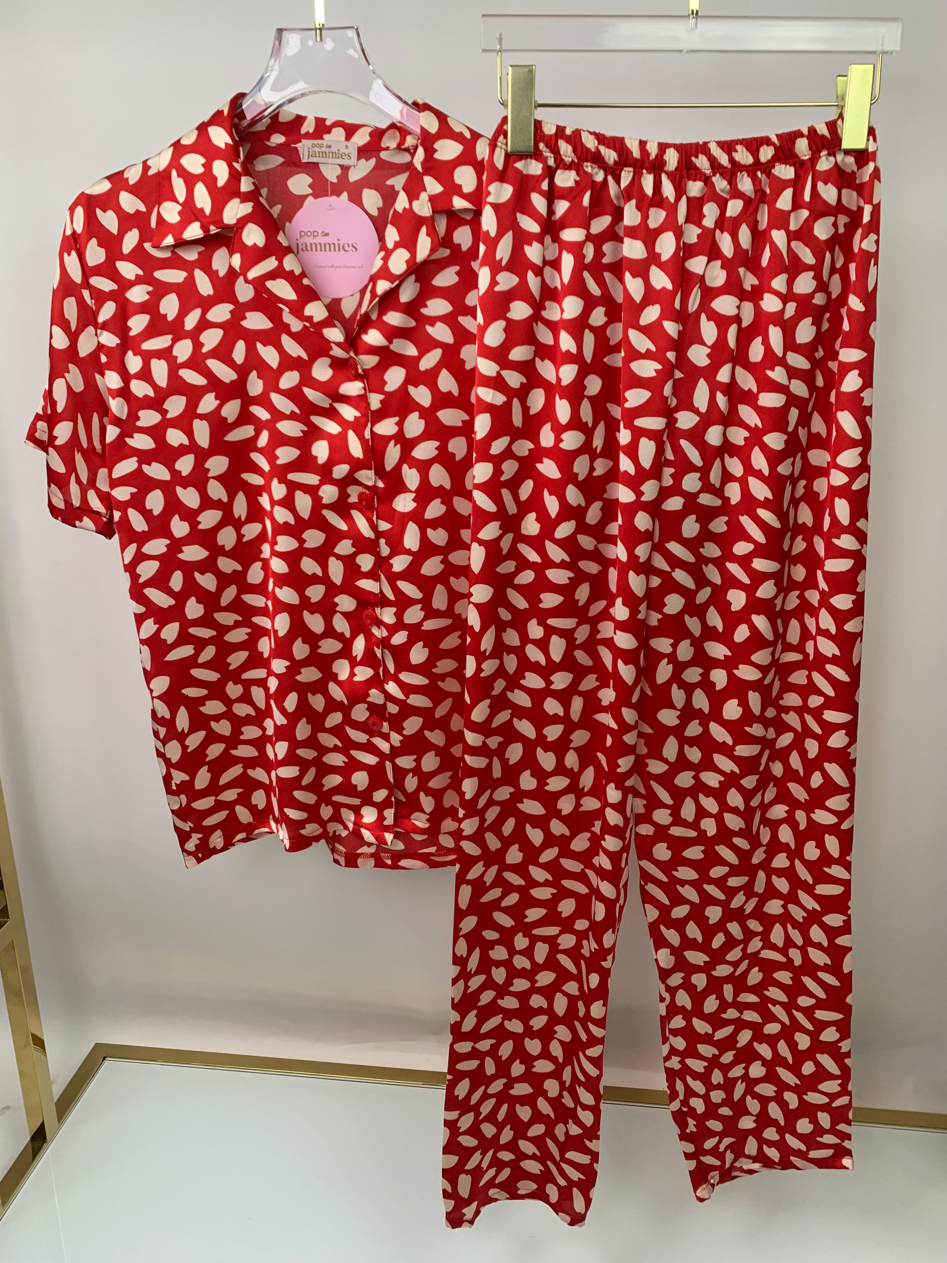 Red and white patterned pajama set on a hanger against a white background - pajama - pj