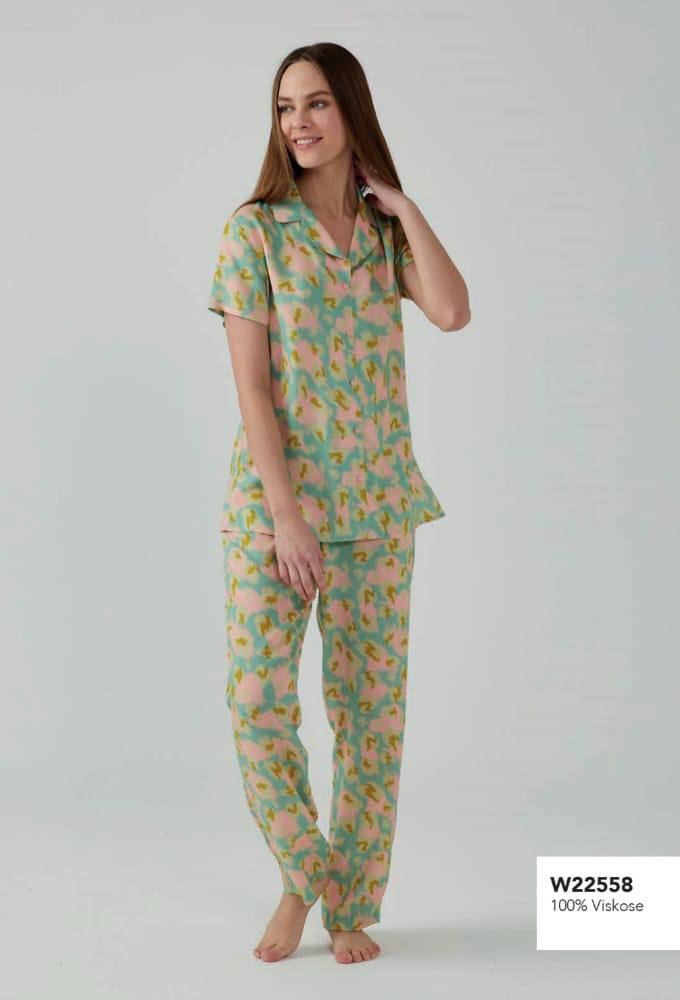 Woman wearing a pastel pyjama set from Popjammies, featuring a short-sleeved button-up top and relaxed fit pants.