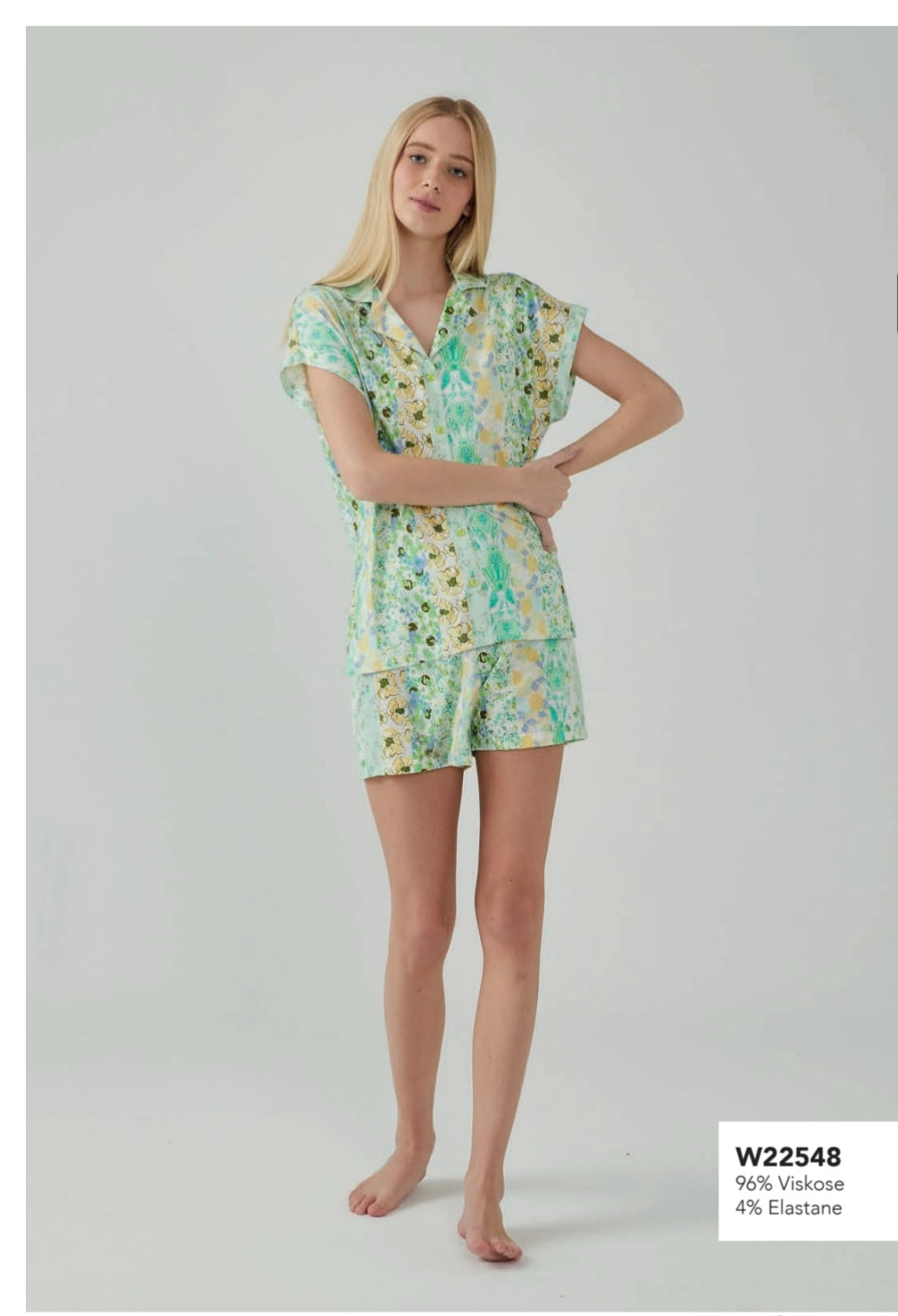 Model wearing Popjammies Tropical Breeze Pyjama Set with a vibrant tropical print, featuring a button-up top and matching shorts.