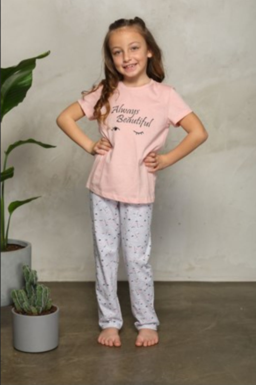 Girl wearing a pink "Hello Beautiful" pyjama set with a pink top featuring the words "Hello Beautiful" and grey pants with cute prints.