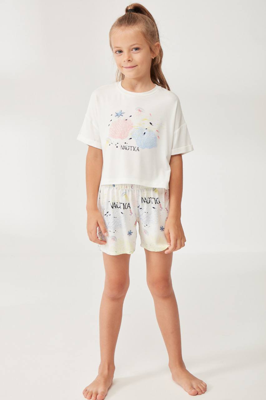 Girl wearing a white t-shirt with pastel-colored coral and sea creature designs paired with matching nautical-themed shorts from Popjammies.