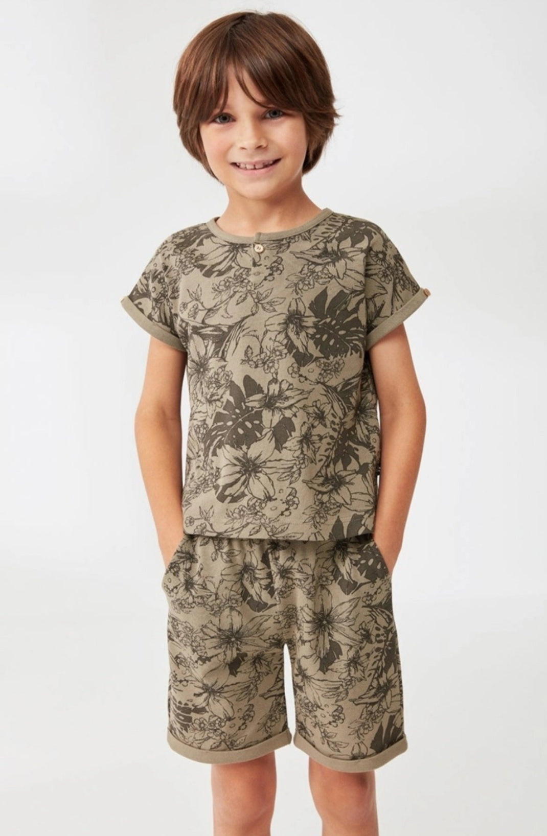 Boy wearing a jungle foliage print short-sleeve top and matching shorts from Popjammies.